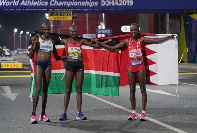 Women's marathon winner Ruth Chepngetich of Kenya, center, poses with runner-up Rose Chelimo (Bahrain), right, and third-place finisher Helalia Johannes of Namibia.