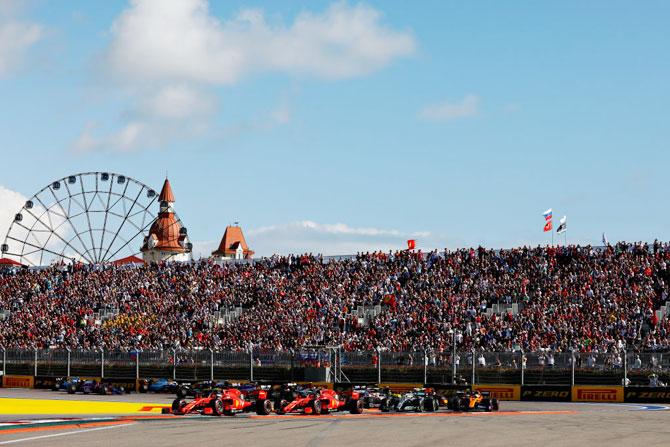 Ferrari's drivers Sebastian Vettel and Charles Leclerc battle for position at the start