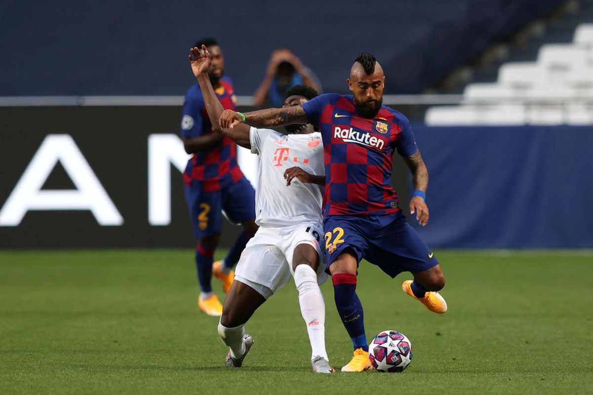 FC Bayern Munich's Alphonso Davies is challenged by FC Barcelona's Arturo Vidal