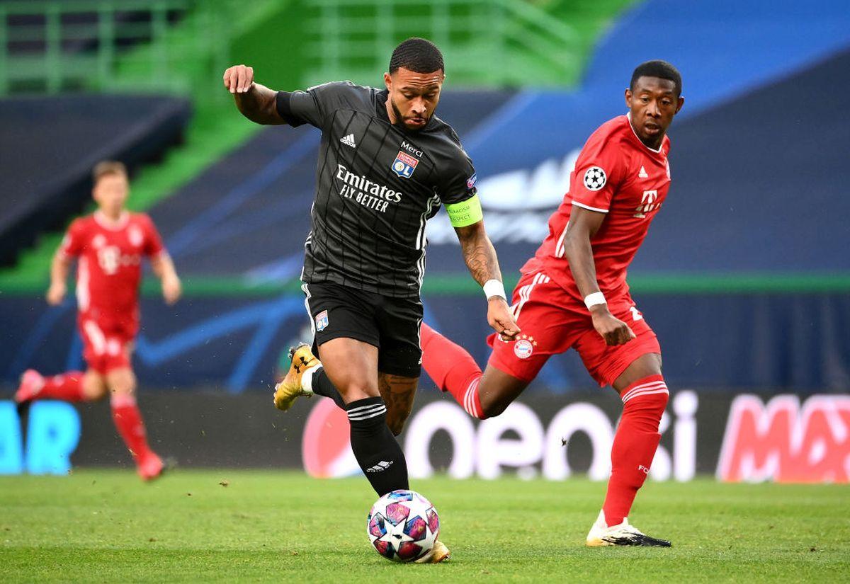 Olympique Lyonnais' Memphis Depay is challenged by Bayern Munich's Jerome Boateng