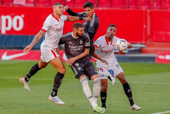 Real Madrid's Karim Benzema in action with Sevilla's Fernando during their La Liga match at Ramon Sanchez Pizjuan, Seville, on Saturday