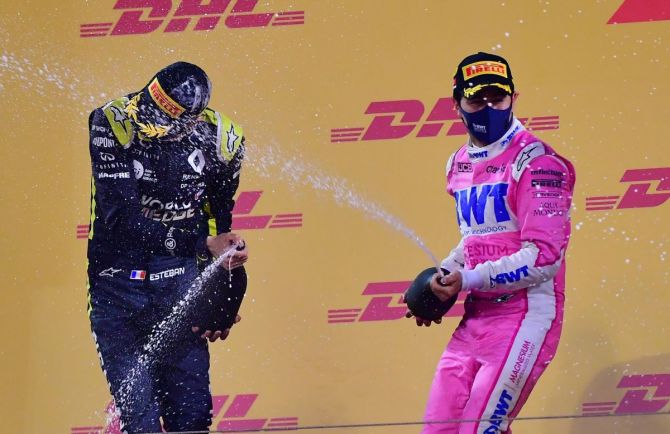 Racing Point's Sergio Perez sprays sparkling wine on Renault's Esteban Ocon as they celebrate on the podium