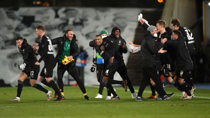 Borussia Moenchengladbach players celebrate on the pitch at full-time after finding out they have qualified for the UEFA Champions League last 16 after their UEFA Champions League Group B match against Real Madrid at Estadio Alfredo di Stefano in Madrid