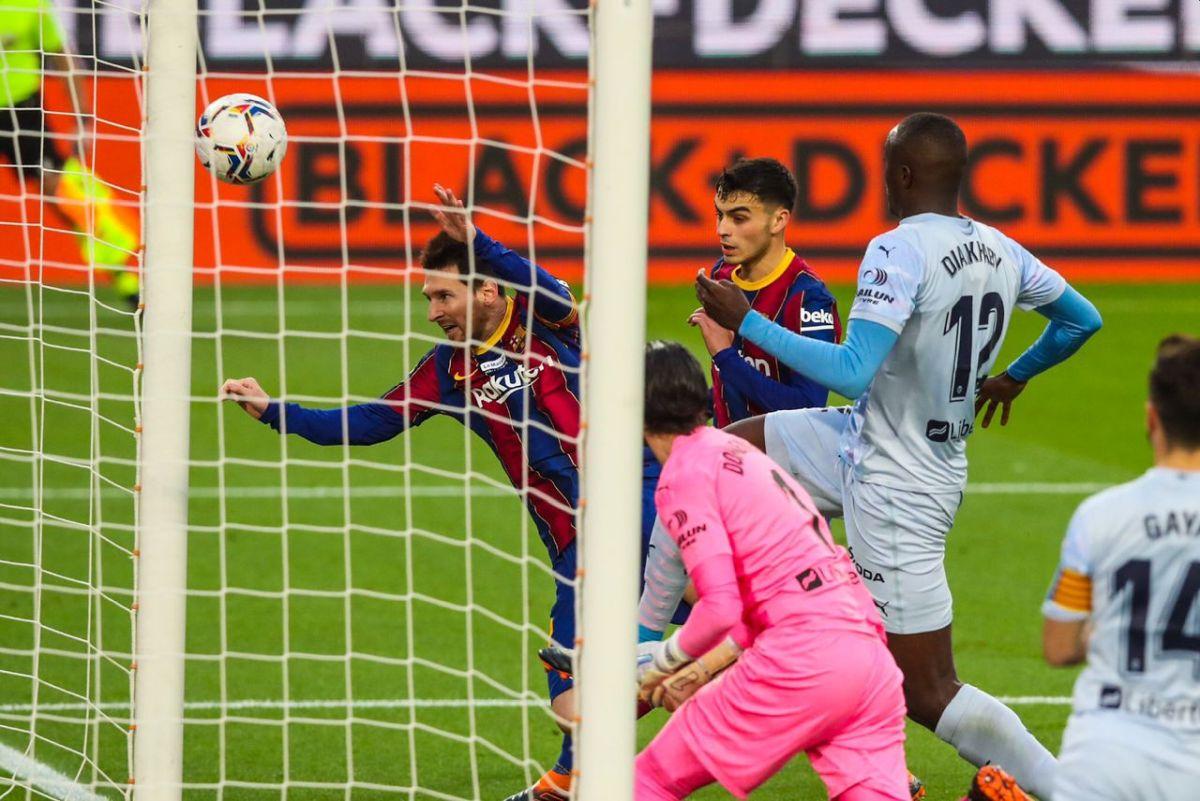 FC Barcelona's Lionel Messi scores through a diving header to score the record-equalling goal during their La Liga match against Valencia on Saturday