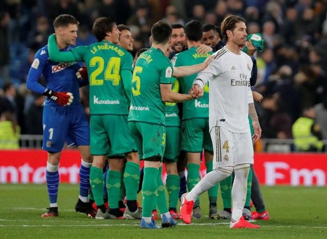 Real Madrid's Sergio Ramos looks dejected as Real Sociedad players celebrate after the Copa del Rey match, at Santiago Bernabeu, in Madrid, on Thursday. 