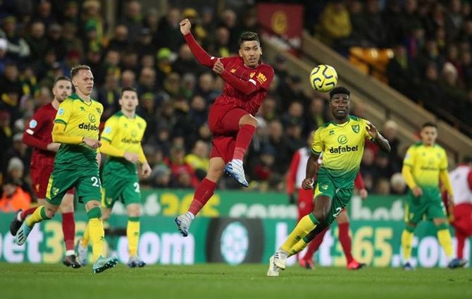 Liverpool's Roberto Firmino breaks through the Norwich defence and shoots at goal.