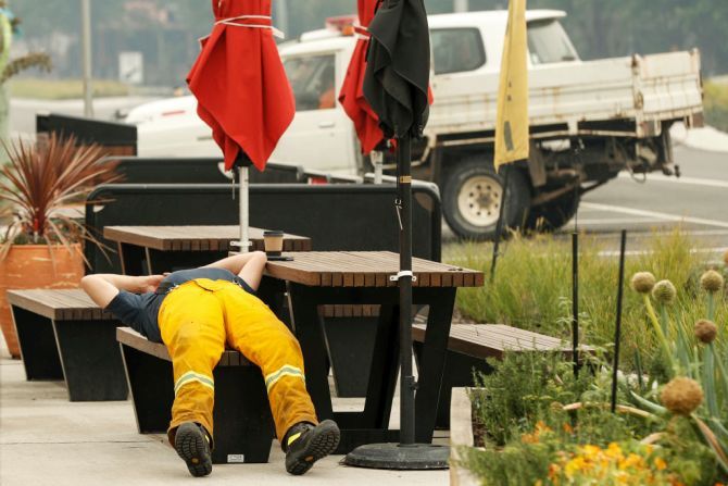A tired firefighter rests outside a cafe in Cann River, Australia, on Monday. Milder weather conditions have provided some relief for firefighters in Victoria as bushfires continue to burn across the East Gippsland area, as clean up operation and evacuations continue. Two people have been confirmed dead and four remain missing. More than 923,000 hectares have been burnt across Victoria, with hundreds of homes and properties destroyed. 14 people have died in the fires in NSW, Victoria and South Australia since New Year's Eve