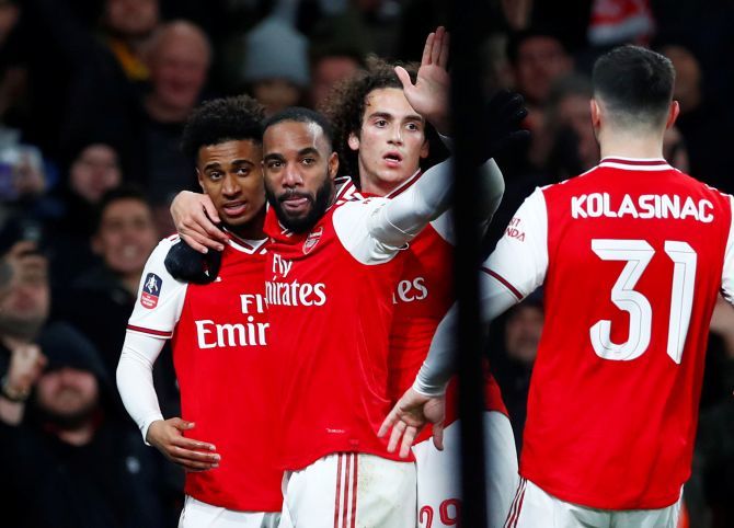 Arsenal's Reiss Nelson celebrates with teammates Alexandre Lacazette, Matteo Guendouzi and Sead Kolasinac after scoring their first goal  against Leeds United in their FA Cup third round match at Emirates Stadium in London on Monday