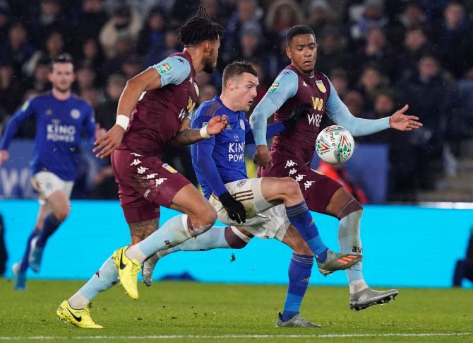 Aston Villa's Tyrone Mings and Ezri Konsa are beaten to the ball by Leicester City's Jamie Vardy during their Carabao League Cup semi-final first leg match at King Power Stadium in Leicester on Wednesday