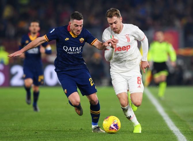 Juventus' Aaron Ramsey in action and AS Roma's Jordan Veretout vie for possession 