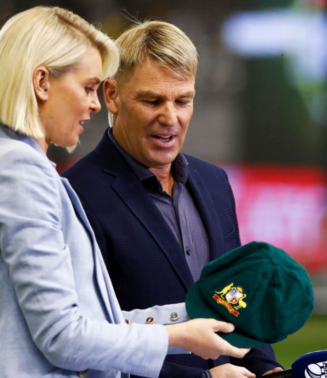 Fox Sports commentator Sarah Jones and Shane Warne, with his baggy green cap which was sold for more than $1 million, with all funds going to the bushfire appeal, ahead of the Big Bash League match between the Melbourne Renegades and the Melbourne Stars at Marvel Stadium in Melbourne on Friday