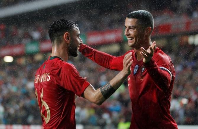 Sporting Lisbon's Bruno Fernandes celebrates with Cristiano Ronaldo after scoring Portugal's second goal in the international friendly against Algeria on- June 7, 2018.