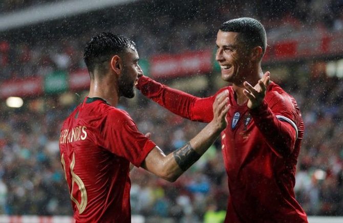 Sporting Lisbon's Bruno Fernandes celebrates with Cristiano Ronaldo after scoring Portugal's second goal in the international friendly against Algeria on- June 7, 2018.
