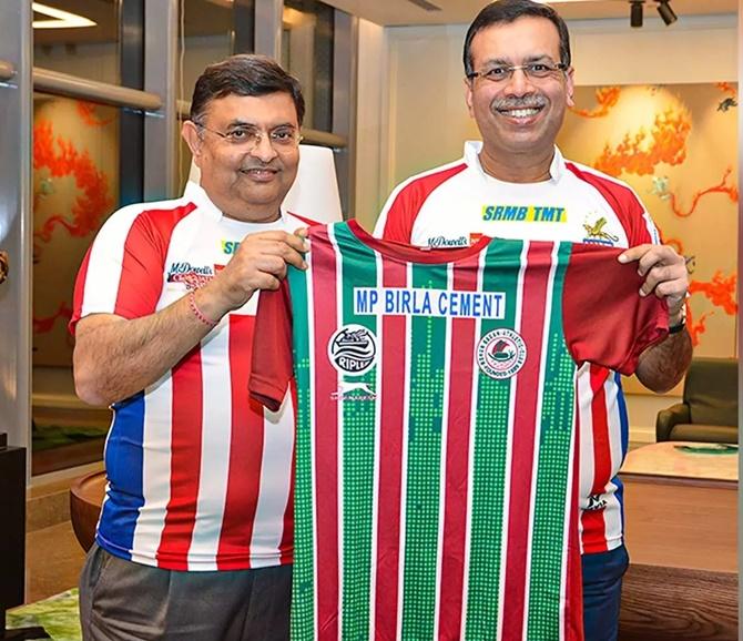 RPSG Group chairman Sanjiv Goenka, right, displays a jersey at the Mohun Bagan-ATK merger on Thursday