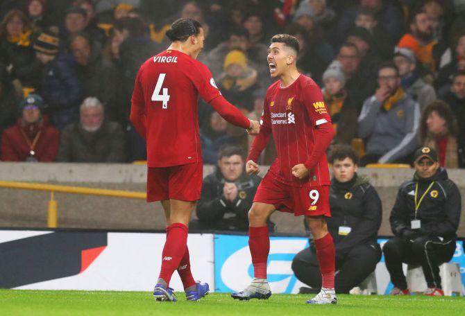 Liverpool's Roberto Firmino celebrates with teammate Virgil van Dijk after scoring the winner against Wolverhampton Wanderers at Molineux in Wolverhampton, United Kingdom