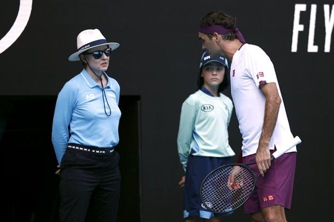 Switzerland’s Roger Federer talks to a line umpire during his Australian Open quarter-final against Tennys Sandgren of the United States.