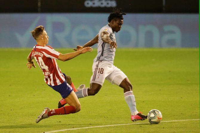 Celta Vigo's Joseph Aidoo and Atletico Madrid's Marcos Llorente vie for possession during their La Liga match at Balaidos in Vigo