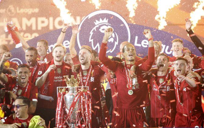 Liverpool's Jordan Henderson and teammates celebrate with the English Premier League trophy at Anfield on Wednesday 