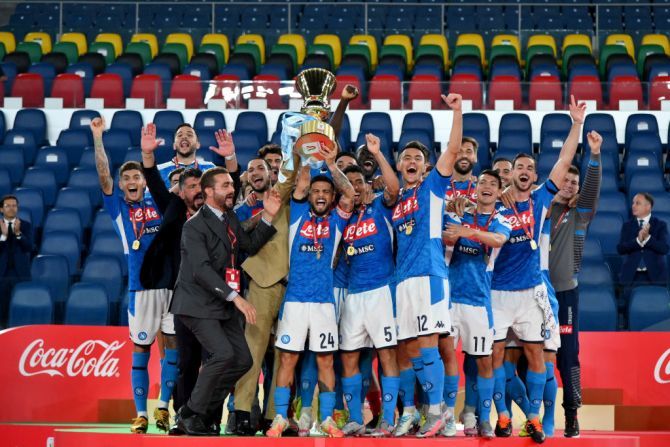 SSC Napoli's players and coach Gennaro Gattuso (extreme left, in black suit) celebrate with the Coppa Italia trophy after defeating Juventus in the final at Olimpico Stadium in Rome on Wednesday