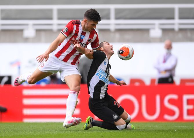 Sheffield United's John Egan in action with Newcastle United's Miguel Almiron