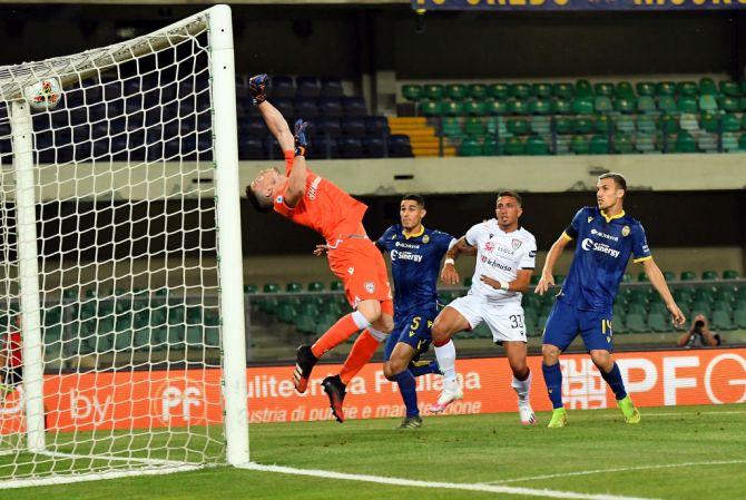 Samuel Di Carmine (obscured) of Hellas Verona scores the opening goal against Cagliari Calcio during their during the Serie A match at Stadio Marcantonio Bentegodi in Verona, Italy