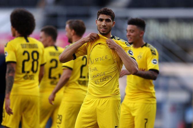 Borussia Dortmund's Achraf Hakimi celebrates scoring their fourth goal with a 'Justice for George Floyd' shirt during their Bundesliga match against Paderborn on Sunday