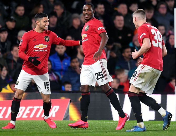 Odion Ighalo, centre, celebrates with his team-mates after scoring the third goal for Manchester United