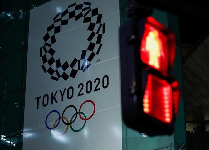 A banner for the upcoming Tokyo 2020 Olympics is seen through a traffic signal in Tokyo, Japan.