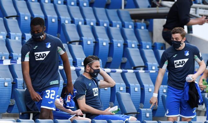 Hoffenheim substitutes wear protective face masks, as play between TSG 1899 Hoffenheim and Hertha BSC at the PreZero Arena, Sinsheim, in Germany resumes behind closed doors.