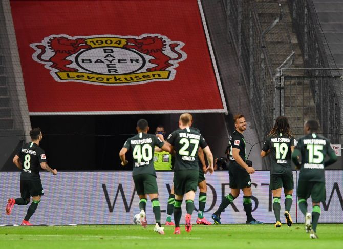 VfL Wolfsburg's Marin Pongracic celebrates with teammates after scoring their fourth goal against Bayer Leverkusen at BayArena, Leverkusen 