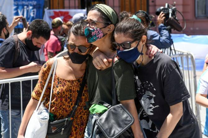 Fans cry as they walk out of the goverment palace Casa Rosada after paying their respects to Diego Maradona in Buenos Aires on Thursday