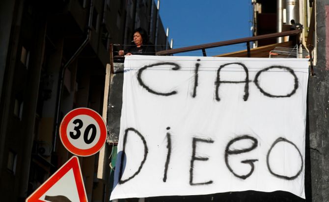 A woman hangs out on a balcony a sheet reading 'Bye Diego' to mourn the death of Argentine soccer legend Diego Maradona, in Naples on Thursday