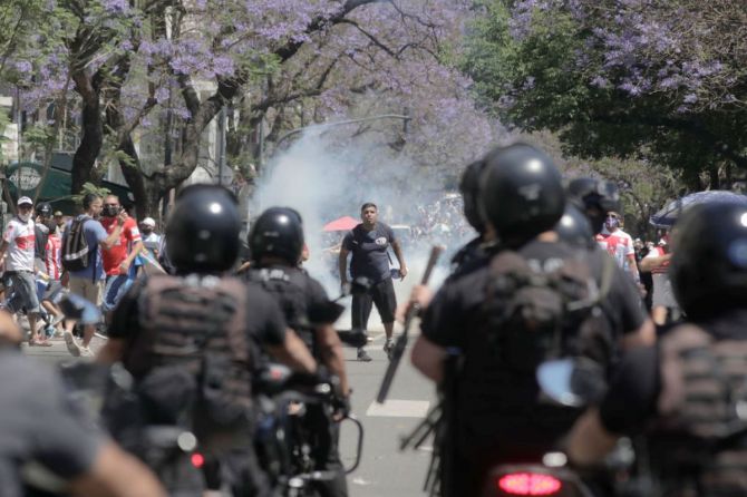 Riot police officers clash with fans of Maradona during the funeral of the late football legend on Thursday