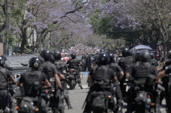 Riot police officers clash with fans of Diego Maradona