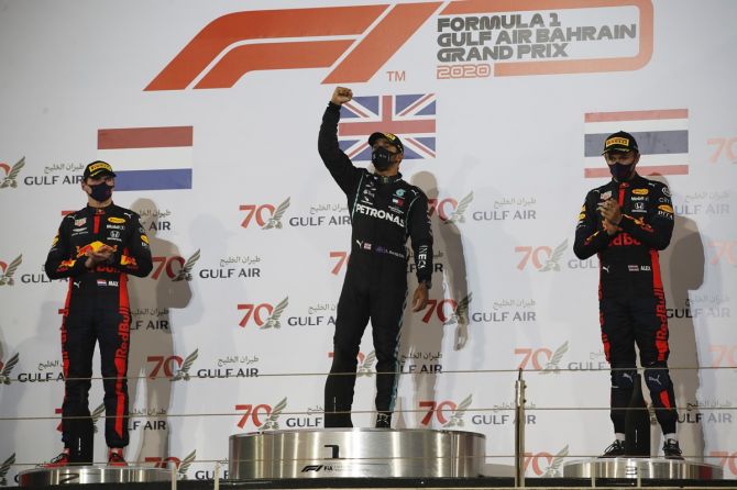 Lewis Hamilton celebrates on the podium alongside second-placed Red Bull's Max Verstappen and third-placed Red Bull's Alexander Albon after winning the Bahrain Grand Prix.