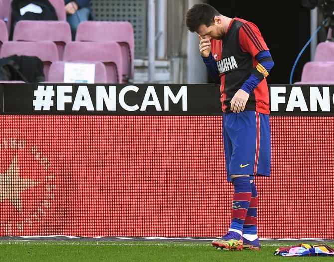 Lionel Messi celebrates scoring Barcelona's fourth goal against Osasuna while wearing a Newell's Old Boys shirt with the number 10 on the back in memory of former footballer Diego Maradona