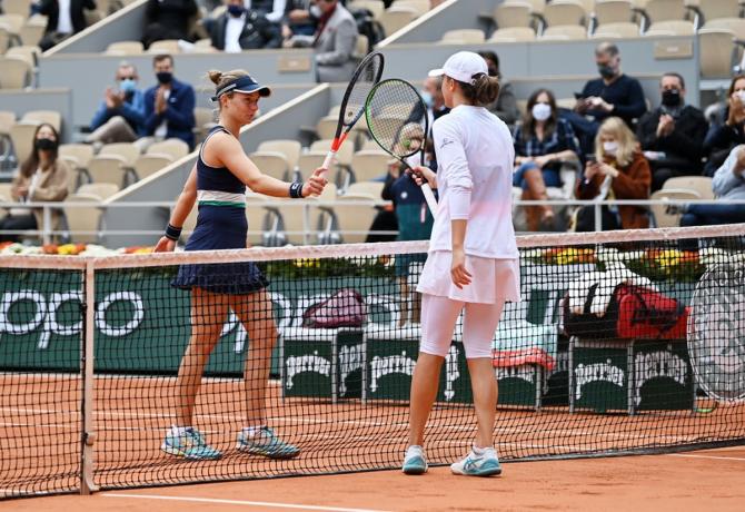 Poland's Iga Swiatek, right, knocks racquets at the net with Argentina's Nadia Podoroska following victory in the semi-finals of the French Open