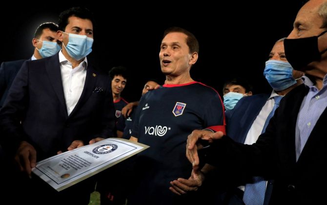 Ezzeldin Bahader, a 74-years-old Egyptian football player of 6th October Club talks with Dr. Ashraf Sobhi, Minister of Youth and Sports (wearing a protective face mask) before a soccer match against El Ayat Sports Club of Egypt's third division league at the Olympic Stadium in the Cairo suburb of Maadi, Egypt October 17, 2020