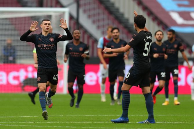 Manchester City's Phil Foden celebrates with teammates after scoring the equaliser during the Premier League match against West Ham United at London Stadium