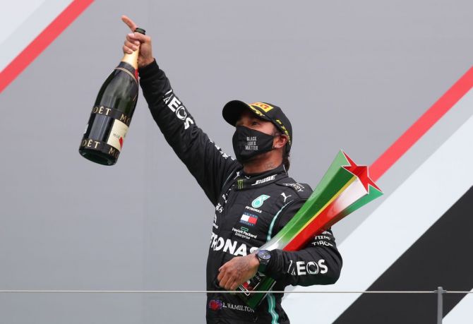 Mercedes' Lewis Hamilton celebrates on the podium after winning the Portuguese F1 Grand Prix at Algarve International Circuit in Portimao on Sunday
