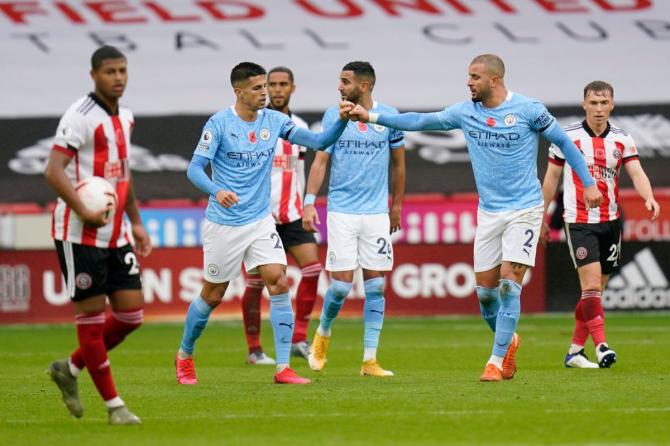 Manchester City's Kyle Walker celebrates with teammate Joao Cancelo after scoring against Sheffield United during their Premier League match at Bramall Lane in Sheffield on Saturday.