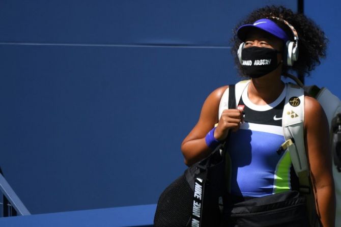 Naomi Osaka walks onto the court wearing a mask with the name of Ahmaud Arbery prior to her third round match against Ukraine's Marta Kostyuk (not pictured)