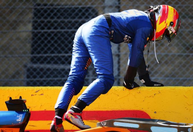 McLaren's Spanish driver Carlos Sainz climbs out of his car after a the collision
