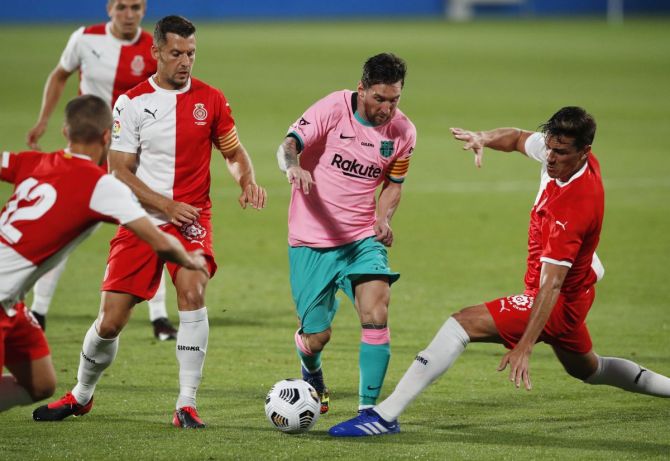 Barcelona's Lionel Messi dribbles past Girona's Bernardo Espinosa, Alex Granell and Enric Franquesa during their La Liga pre-season at the Johan Cruyff Stadium, Barcelona on Wednesday