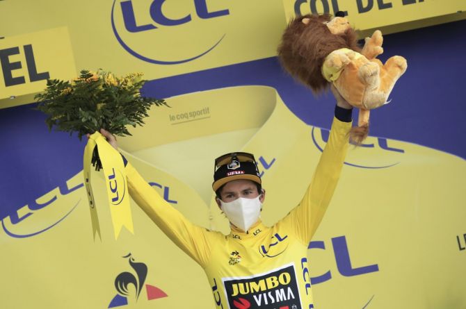 Team Jumbo-Visma rider Primoz Roglic of Slovenia, wearing the overall leader's yellow jersey, celebrates on the podium after Stage 17 Grenoble to Meribel Col De La Loze in France on Wednesday 