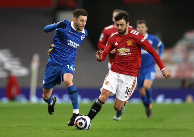 Brighton's Adam Lallana and Manchester United's Bruno Fernandes vie for possession 