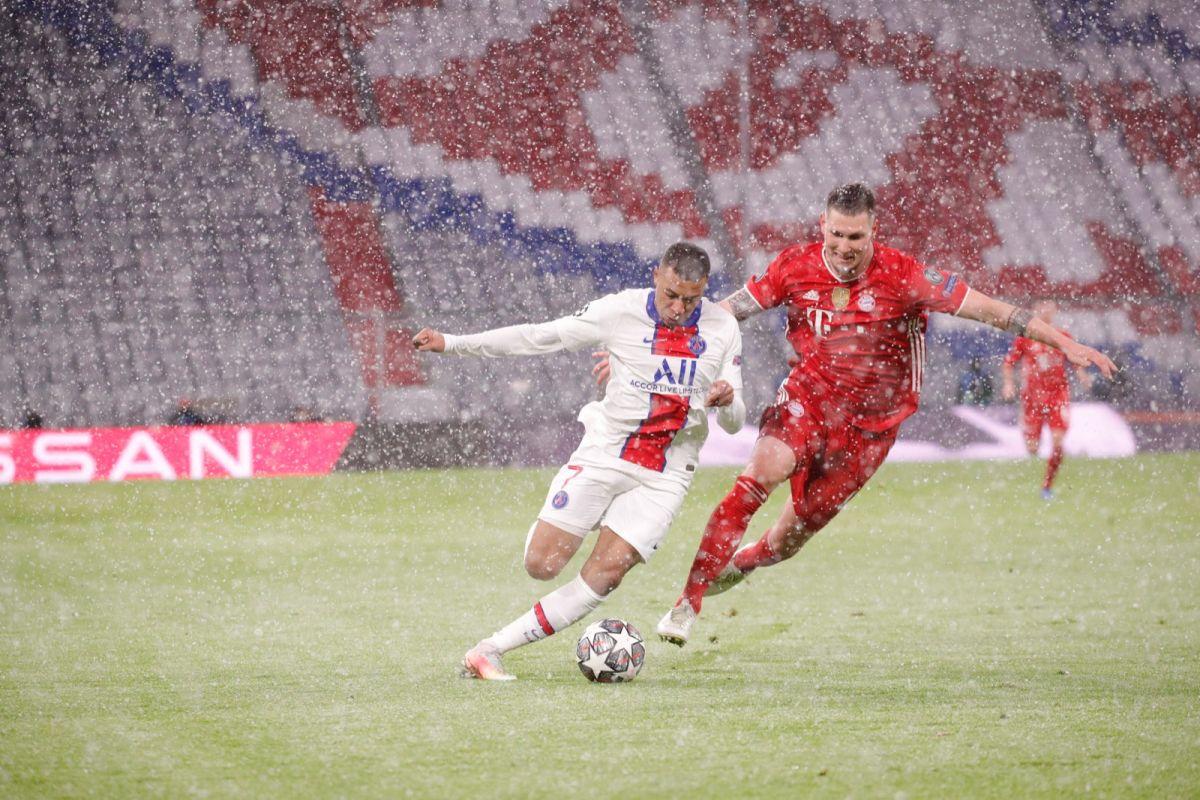 PSG's Kylian Mbappe is challenged by a Bayern Munich player during their match in Munich