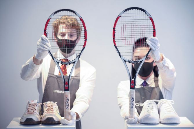 Christie's gallery assistants pose with rackets and sneakers from 'The Championships, Wimbledon, 2007' and 'French Open, 2009' lots included in 'The Roger Federer Collection', due to be sold at auction, here on display at Christie's auction house in London, Britain, on Tuesday