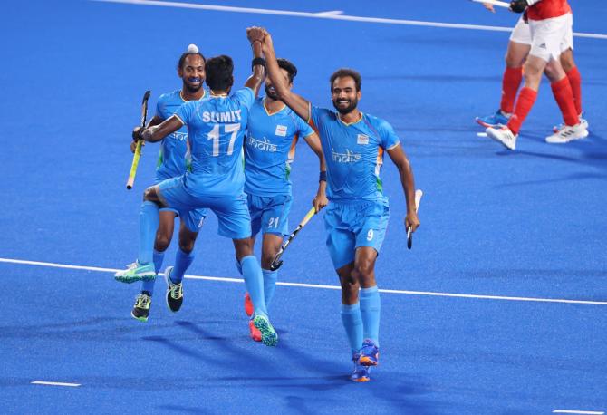 Gurjant Singh celebrates with India teammates Sumit, Hardik Singh and Shamsher Singh after scoring their second goal during the Olympics men's hockey quarter-final against Great Britain 