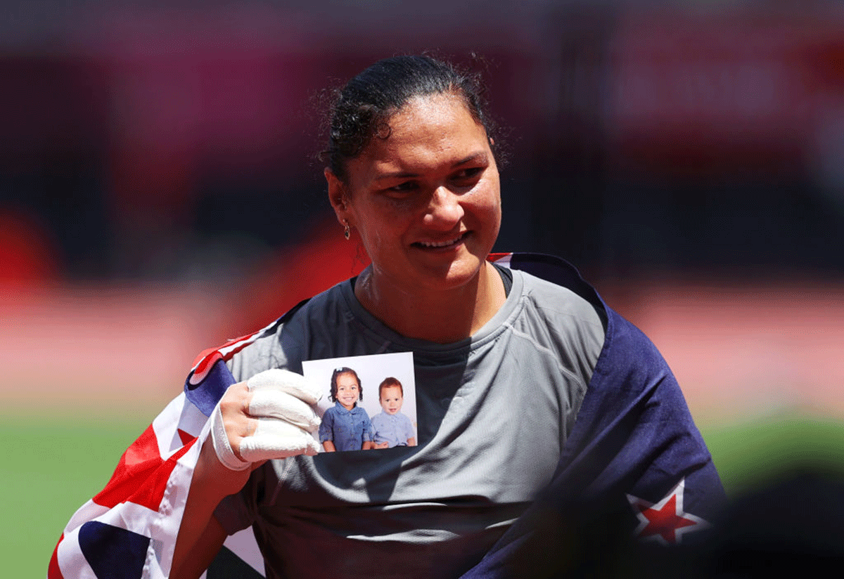 New Zealand's Valerie Adams holds a photo of her daughter Kimoana, 3, and son Kepaleli, 2, after winning the women's Shot Put bronze medal